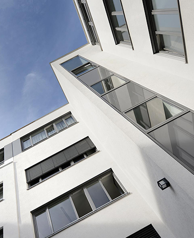 Ansicht eines Teils der Außenfassade des Krankenhauses vom Innenhof aus – Blick von unten in Richtung Himmel.