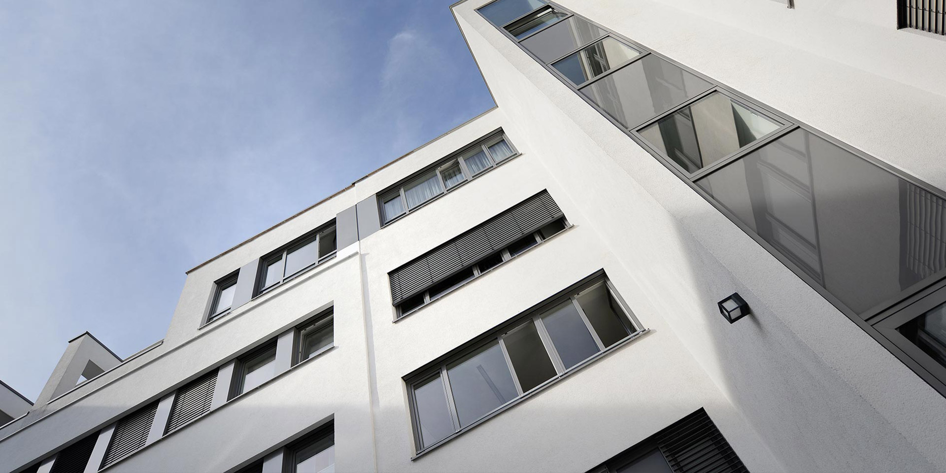 Ansicht eines Teils der Außenfassade des Krankenhauses vom Innenhof aus – Blick von unten in Richtung Himmel.